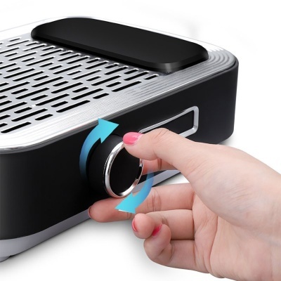 Dispositivo de cozinha preto e cinzento com botão ajustável sendo rodado por mão feminina