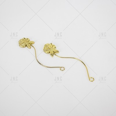Par de alfinetes dourados decorativos em forma de flores sobre fundo branco