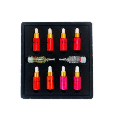 Conjunto de frascos coloridos com pipetas em caixa preta