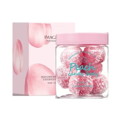 Frasco transparente com doces Peach Candy Body rosa e caixa rosa claro com detalhes de pétalas