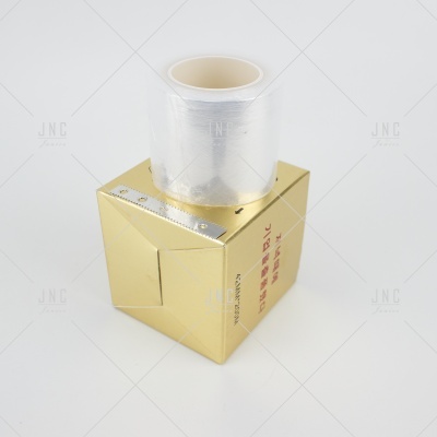 Rolo de película transparente sobre caixa dourada com texto em fundo branco