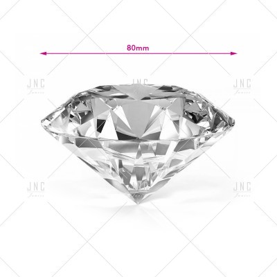 Diamante artificial facetado transparente com diâmetro de 80 mm sobre fundo branco.