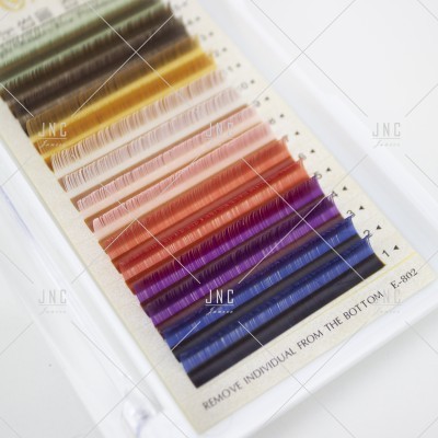 Conjunto de pestanas postiças coloridas em várias tonalidades numa cartela branca.