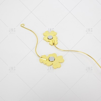 Brincos dourados em forma de flor com detalhe prateado