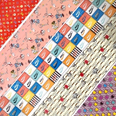 Tecido com padrões variados de marcas famosas, personagens e cerejas em faixas diagonais coloridas.