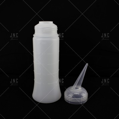 Frasco de plástico branco translúcido com tampa de bico removida sobre fundo preto