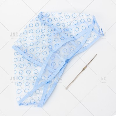 Cueca azul claro com círculos azuis e agulha metálica sobre fundo branco