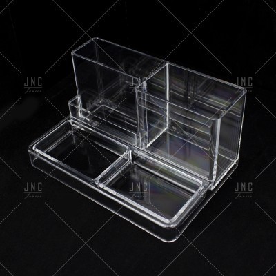 Organizador acrílico transparente com compartimentos sobre fundo preto