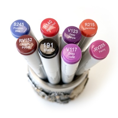 Marcadores coloridos em suporte rústico com céu azul ao fundo