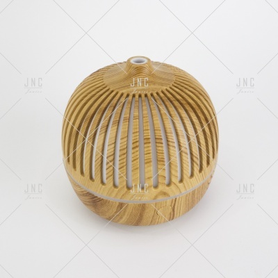 Difusor redondo em madeira clara com ranhuras verticais e topo pequeno