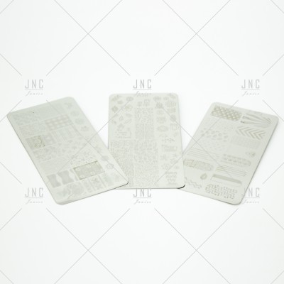 Três placas retangulares brancas com padrões cortados colocadas em superfície branca