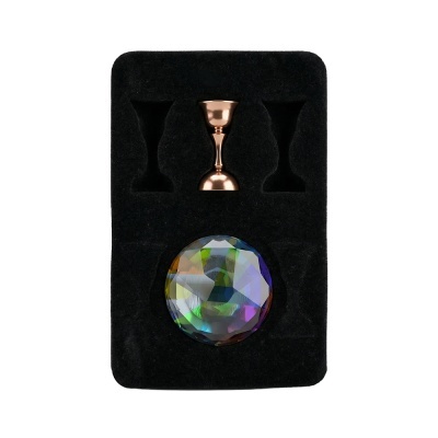 Jogo com copos medidores metálicos e esfera facetada colorida numa base de veludo preto