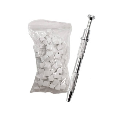 Saco com pequenas esponjas brancas ao lado de ferramenta metálica prateada sobre fundo branco