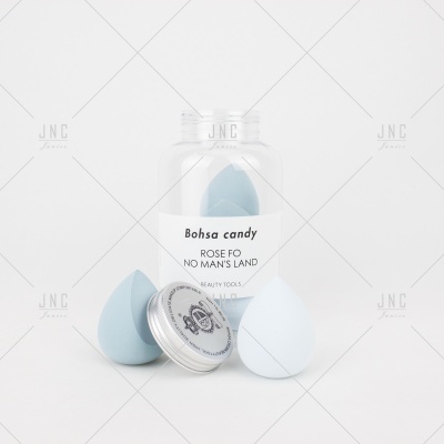 Frasco transparente com três esponjas de maquilhagem azuis claras e tampa metálica com selo