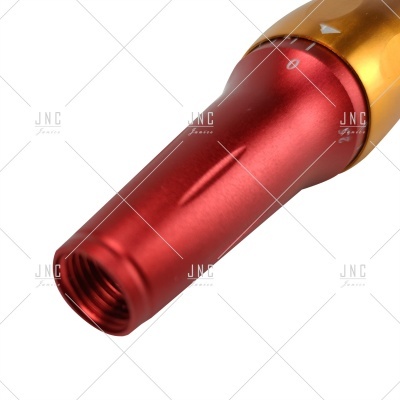 Peça metálica cilíndrica vermelha e dourada com roscas internas