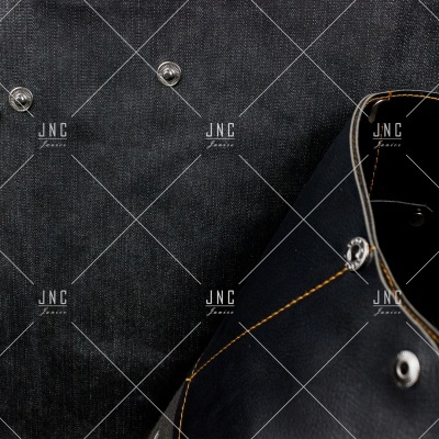 Mochila preta com detalhes metálicos e costura laranja