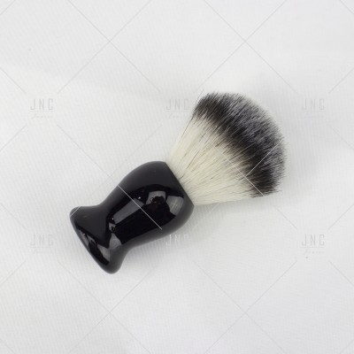 Pincel de barbear com cabo preto e cerdas brancas e pretas sobre fundo branco