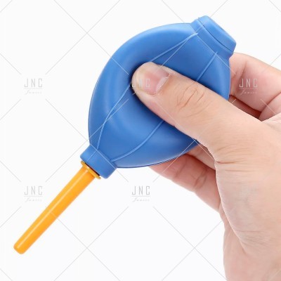 Pera de borracha azul com bocal amarelo segurada por uma mão