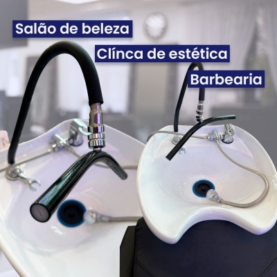 Duas pias brancas com torneiras pretas para lavagem de cabelo em salão de beleza