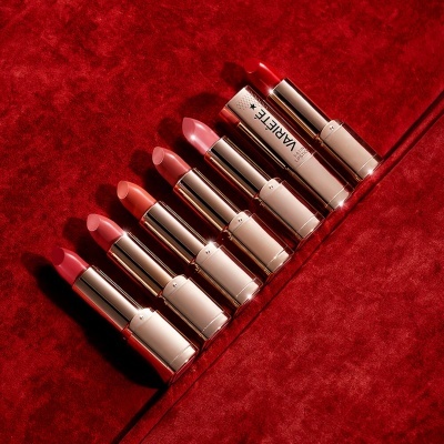 Sete batons alinhados sobre superfície vermelha aveludada