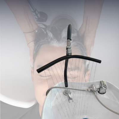 Pessoa sendo lavada e dispositivo de aspersão preto em pia branca.