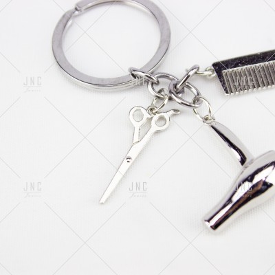 Chaveiro com miniaturas de tesoura, pente e secador de cabelo