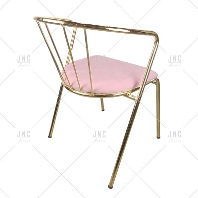 Cadeira dourada com assento rosa e design moderno