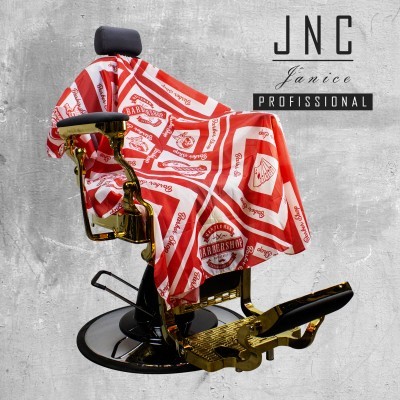 Capa de barbeiro vermelha e branca com estampas sobre cadeira de barbeiro preta e dourada