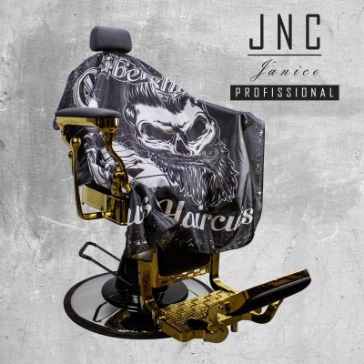 Cadeira de barbeiro vintage dourada com capa preta estampada e parede cinzenta ao fundo