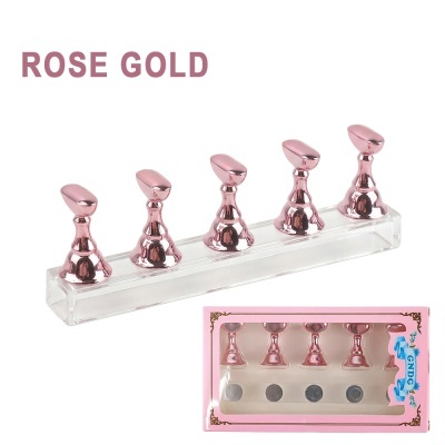 Martelos de unhas cor ouro rosa com base transparente e embalagem cor-de-rosa.