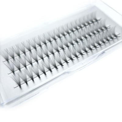 Conjunto de pestanas postiças pretas agrupadas em tufos numa embalagem clara