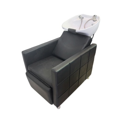 Cadeira preta de lavagem de cabelo com lavatório branco