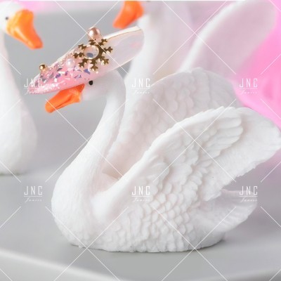 Escultura branca de cisne com acessório decorativo transparente e dourado no bico