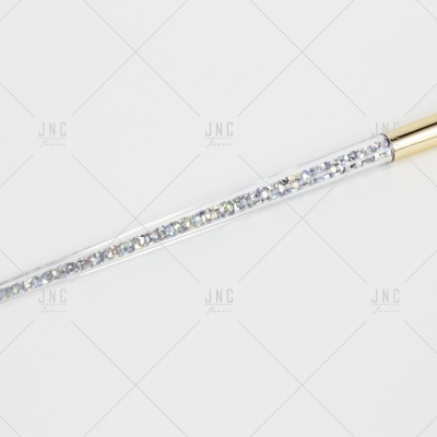 Haste transparente com cristais e extremidade dourada.