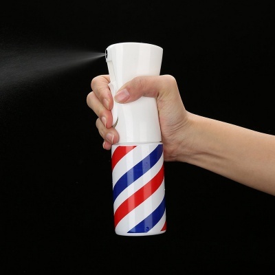 Mão segurando frasco branco com padrão de riscas vermelhas, azuis e brancas enquanto pulveriza líquido