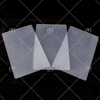 Três placas retangulares transparentes com desenhos gravados