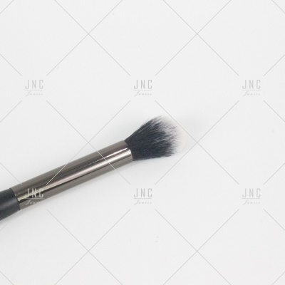 Pincel de maquilhagem com cerda branca e preta e cabo preto sobre fundo branco