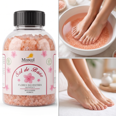 Frasco de sal de banho com cristais cor-de-rosa e pés femininos num recipiente com água e sal.