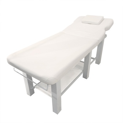 Mesa de massagem branca com almofada retangular e estrutura em madeira