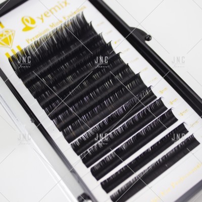 Conjunto de pestanas posticas pretas organizadas em linhas dentro de caixa de plástico.