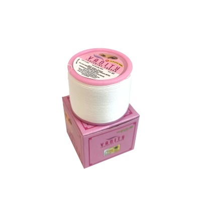 Rolo de fio branco com etiqueta rosa sobre caixa rosa