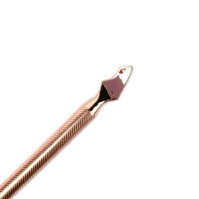 Instrumento metálico dourado para cuidado das unhas