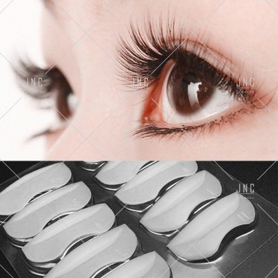 Close-up de olhos com pestanas longas e suporte branco para pestanas postiços em embalagem preta