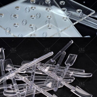 Palitos e placa transparente para exposição, sobre fundo preto e branco