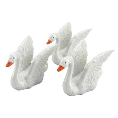 Três figuras decorativas de cisnes brancos em cerâmica com bicos laranja