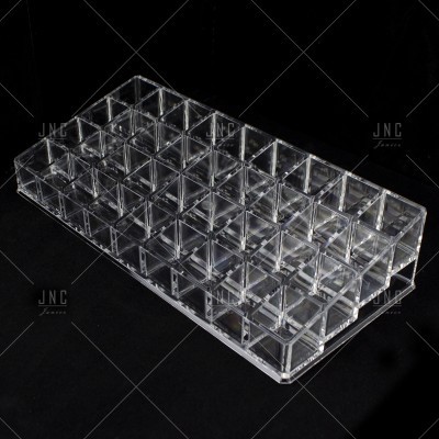 Organizador acrílico transparente com 48 compartimentos sobre fundo preto