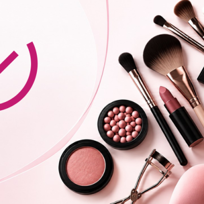 Conjunto de maquilhagem com sombras, batom, blush, pincéis, esponja, aplicador de pestanas sobre fundo rosa claro
