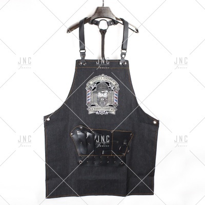 Avental de trabalho preto em denim com bolso de couro e emblema bordado