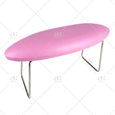 Mesa de pau para unhas cor de rosa com tampo oval e pernas metálicas.