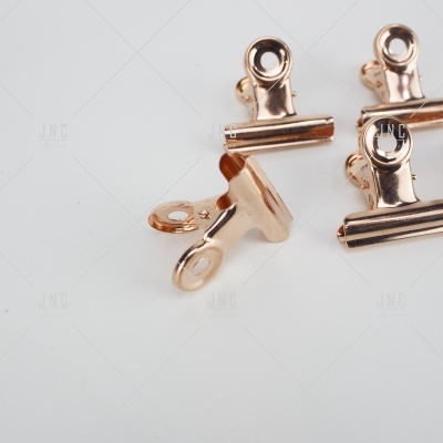 Clips metálicos cobre em superfície branca